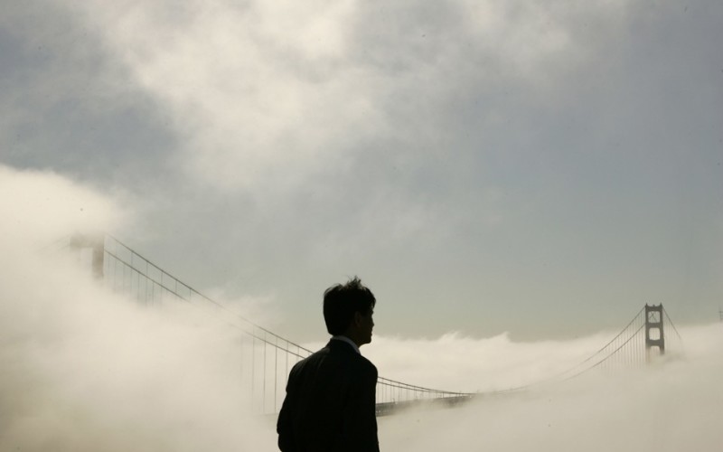 A man takes in the view of the fog-shrouded Golden Gate Bridge from the Marin Headlands in Sausalito, California September 24, 2008.  REUTERS/Robert Galbraith (UNITED STATES) - RTX8VX4